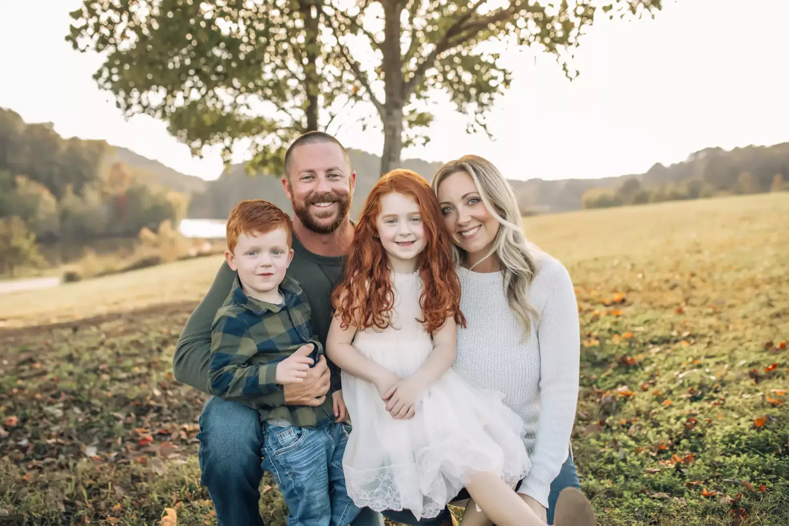 The Payne family, owners of ProScapes Complete Landscape Service smiling together outdoors in a field in Covington, GA.
